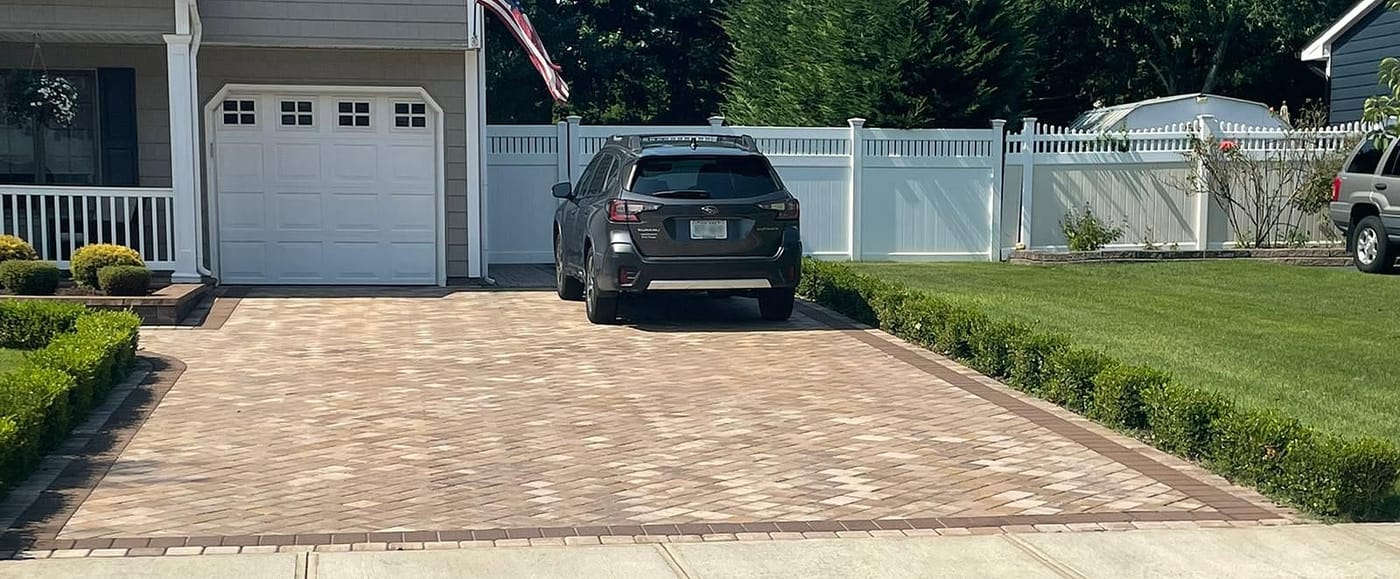Paver driveway with a parked car